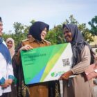 Walikota Banda Aceh Illiza Saaduddin menyerahkan kartu jaminan sosial kepada tenaga kerja rentan secara simbolis di Halaman Balai Kota Banda Aceh, Jumat (15/5/2026). Foto: Dok. Humas Pemko Banda Aceh