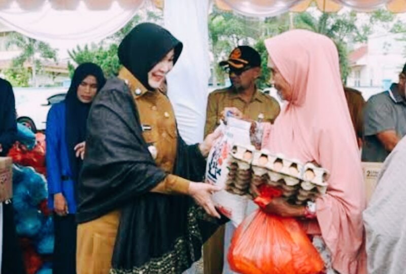Wali Kota Banda Aceh Illiza Sa'aduddin Djamal menyerahkan sembako kepada warga saat meninjau pasar murah di Perumdam Tirta Daroy. Foto: Humas Banda Aceh