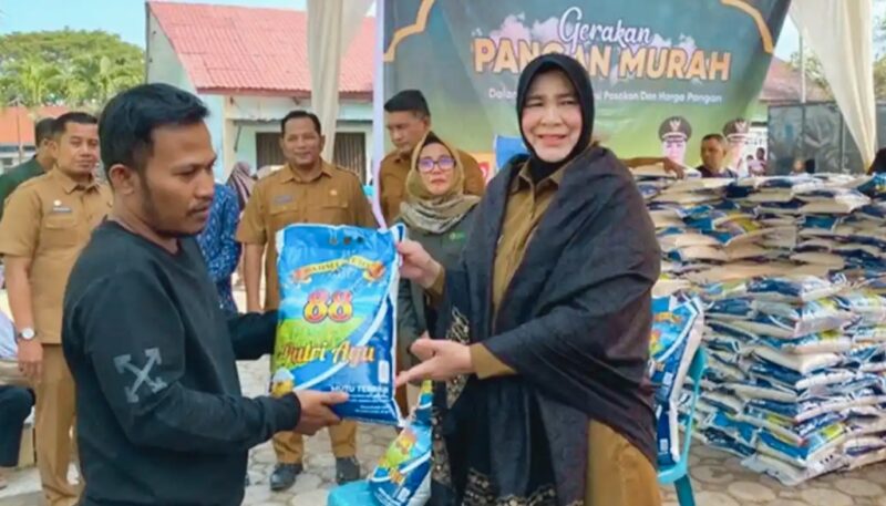 Wali Kota Banda Aceh, Illiza Sa’aduddin Djamal menyerahkan sembako kepada warga saat meninjau Gerakan Pangan Murah di halaman Kantor DPPKP Kota Banda Aceh, Selasa (10/3/2026). Foto: Humas Banda Aceh