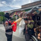 Personel Polwan Ditsamapta Polda Aceh menyerahkan paket sembako kepada warga kurang mampu dalam kegiatan Jum’at Berkah di kawasan Banda Aceh, Jumat (8/5/2026). Foto: Dok. Istimewa 