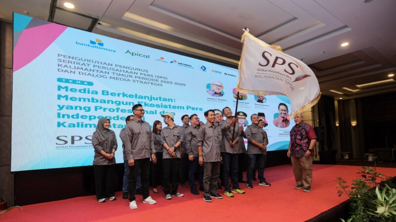 Ketua SPS Pusat Januar P Ruswita menyerahkan bendera pataka kepada Ketua SPS Kaltim terpilih Ajid Kurniawan dalam pelantikan pengurus SPS Kaltim periode 2025-2029 di Ballroom Hotel Grand Tjokro Balikpapan, Rabu (20/5/2026). Foto: Dok. Istimewa 
