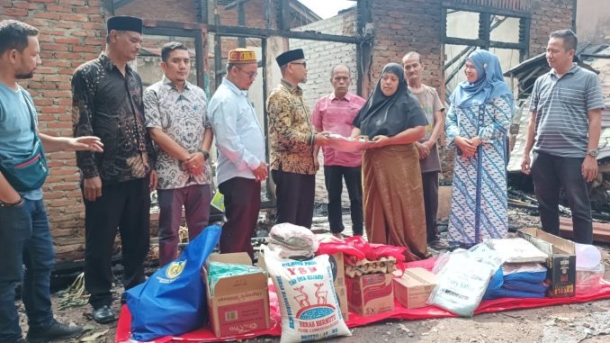 Sekdako Banda Aceh Ir. Jalaluddin, ST, MT di Dampingi Kadis Sosialnya Sukmawati menyerahkan Bantuan Masa panik kepada korban kebakaran Rumah di Kecamatan Ule Kareng. Foto: Dok. Dinsos Kota Banda Aceh