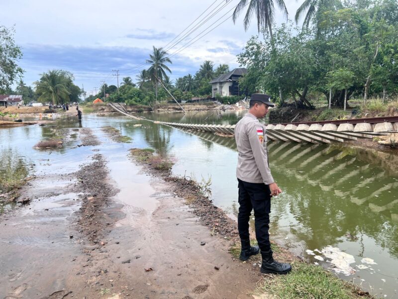 Personel Polsek Muara Batu bergerak cepat memantau dan mengantisipasi dampak abrasi serta naiknya air laut akibat pasang purnama yang menggenangi badan jalan, perlintasan rel kereta api dan permukiman warga di Dusun Pasi, Desa Keude Bungkah, Kecamatan Muara Batu, Kabupaten Aceh Utara, Sabtu (16/5/2026). Dok. Polres Lhokseumawe