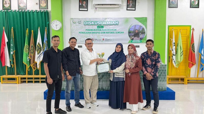 Supervisor KPM Tematik 2026 UNADA Banda Aceh, Adnin AS, S.Pd., M.Pd., menyerahkan cendera mata kepada narasumber Fitrianti, S.Sos.I., M.HSc. usai Diskusi Ilmiah bertema 
