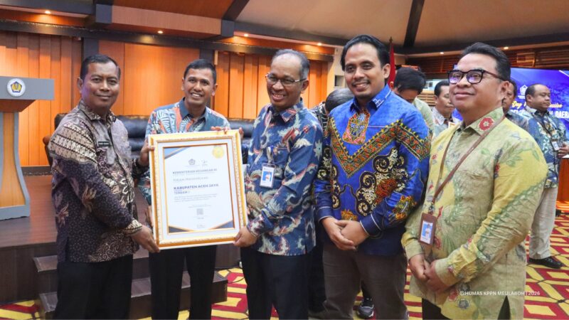 Kepala DPMPKB Aceh Jaya, Dahrial Saputra, menerima penghargaan Kabupaten Terbaik I atas Kinerja Penyaluran Dana Desa Tercepat Tahun 2026. Banda Aceh, Kamis (25/6/2026). Foto: Dok. Pemkab Aceh Jaya
