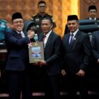 Ketua DPRA Zulfadhli bersama Gubernur Aceh Muzakir Manaf menerima Laporan Hasil Pemeriksaan (LHP) BPK RI atas Laporan Keuangan Pemerintah Aceh Tahun 2025 dan Pengelolaan Dana Otonomi Khusus Aceh dalam Rapat Paripurna DPRA di Banda Aceh, Senin (22/6/2026). Foto: Dok. DPRA