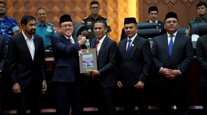 Ketua DPRA Zulfadhli bersama Gubernur Aceh Muzakir Manaf menerima Laporan Hasil Pemeriksaan (LHP) BPK RI atas Laporan Keuangan Pemerintah Aceh Tahun 2025 dan Pengelolaan Dana Otonomi Khusus Aceh dalam Rapat Paripurna DPRA di Banda Aceh, Senin (22/6/2026). Foto: Dok. DPRA