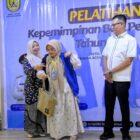 Kabid Kesetaraan Gender DP3A P2KB, Cut Yuni Marlita S.KM M.K.M menyerahkan rompi kepada peserta untuk mengikuti Pelatihan Kepemimpinan Bagi Perempuan Tahun 2026 di Hotel Hanifi, Banda Aceh, Kamis (04/06/2026). Foto: Dok. Bedu Saini