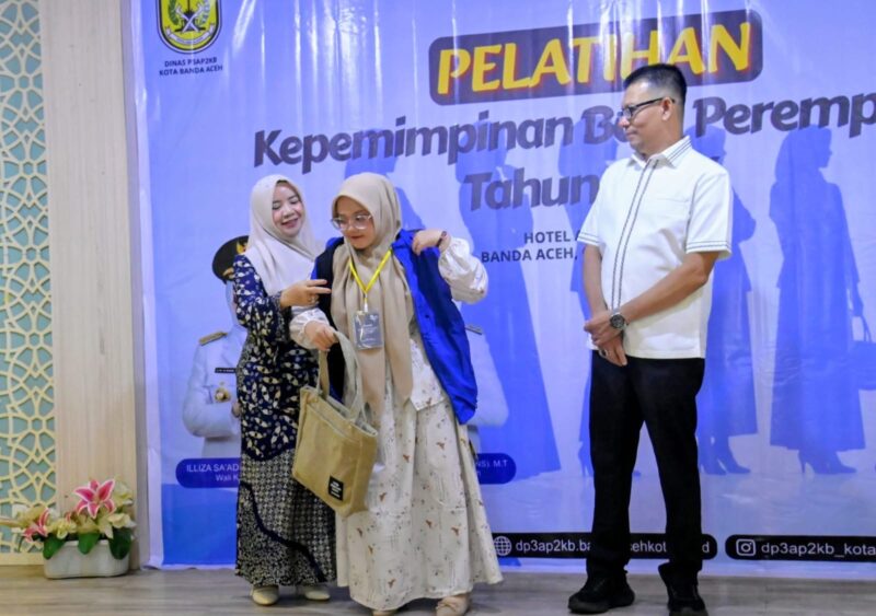 Kabid Kesetaraan Gender DP3A P2KB, Cut Yuni Marlita S.KM M.K.M menyerahkan rompi kepada peserta untuk mengikuti Pelatihan Kepemimpinan Bagi Perempuan Tahun 2026 di Hotel Hanifi, Banda Aceh, Kamis (04/06/2026). Foto: Dok. Bedu Saini