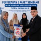 Direktur Perumdam Tirta Abdya, Riza Ariffandi menyerahkan bingkisan sembako kepada petugas sebelum diserahkan kepada pelanggan baru. Foto. Dok. Teukunizar/noa.co.id