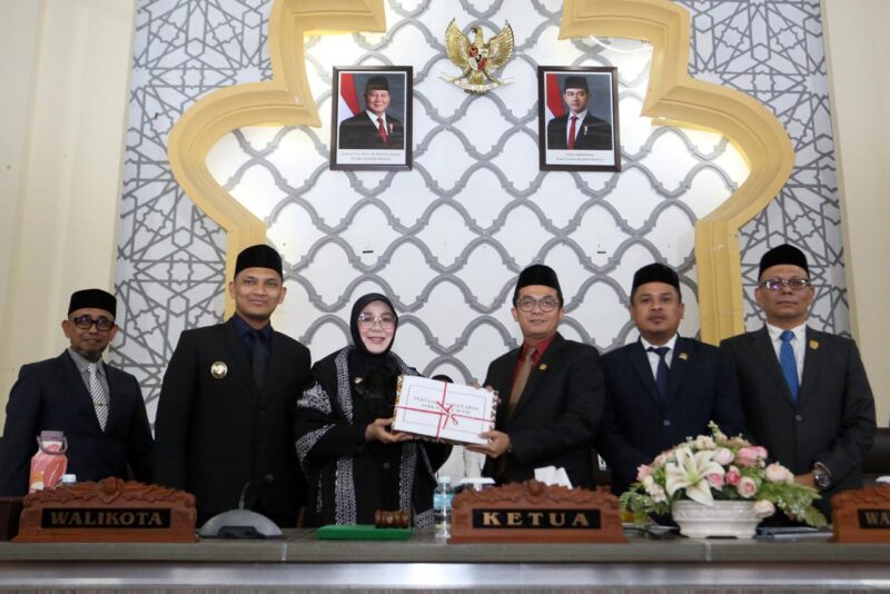 Wali Kota Banda Aceh Illiza Sa’aduddin Djamal menyerahkan Raqan Pertanggungjawaban Pelaksanaan APBK 2025 kepada DPRK Banda Aceh sekaligus menyampaikan capaian opini WTP ke-18 berturut-turut dari BPK RI, Senin (13/7/2026). Foto: Dok. Prokopim Kota Banda Aceh