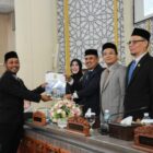 M. Zidan Al Hafidh, S.Ked., M.M., anggota Banggar saat menyerahkan pandangan banggar kepada pimpinan, Wakil Ketua I DPRK Banda Aceh, Daniel Abdul Wahab, didampingi Ketua DPRK Banda Aceh, Irwansyah, ST, serta Wakil Ketua II, Musriadi Aswad. Serta disaksikan oleh Wali Kota Banda Aceh, Illiza Sa'aduddin Djamal dalam rapat paripurna DPRK Banda Aceh dengan agenda penyampaian pendapat, usul, dan saran Banggar terhadap Rancangan Qanun (Raqan) tentang Laporan Keterangan Pertanggungjawaban (LKPJ) Wali Kota Banda Aceh, di Gedung DPRK Banda Aceh, Kamis (23/7/2026). Foto: Dok. DPRK Banda Aceh