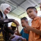 Ketua TP-PKK Aceh Ny. Marlina Muzakir, membagikan seragam sekolah kepada siswa-siswa pada peringatan Hari Anak Nasional 2026, di SLB Negeri Pembina Aceh Tamiang, Kamis (23/7/2026). Foto: Dok. Biro Adpim Setda Aceh 