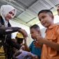 Ketua TP-PKK Aceh Ny. Marlina Muzakir, membagikan seragam sekolah kepada siswa-siswa pada peringatan Hari Anak Nasional 2026, di SLB Negeri Pembina Aceh Tamiang, Kamis (23/7/2026). Foto: Dok. Biro Adpim Setda Aceh 