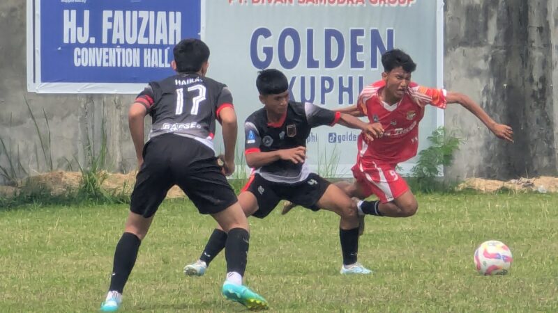 Pemain Persimura Bueureuneun U-17 memakai kostum warna merah dikawal dua pemain lawan pada pertandingan Piala Soeratin U-17 di Stadion Galaticos Bireuen, Rabu (15/7/2026) (Foto.Amir Sagita.NOA.co.id)