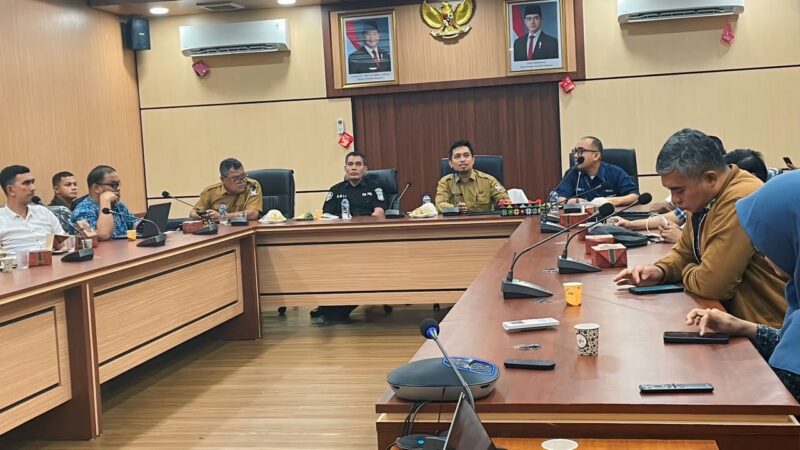 Kepala Dinas Kominsa Aceh Barat Dedi Mulianda, S.IP., M.Si. memaparkan rencana kerja sama pemanfaatan videotron sebagai media layanan informasi publik dan promosi daerah kepada perwakilan BUMN, perusahaan, serta instansi vertikal di Ruang Rapat Teuku Umar Setdakab Aceh Barat, Selasa (21/7/2026). Foto: Dok. Istimewa 