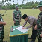 Bupati Pidie H. Sarjani Abdullah bersama Dansatgas TMMD ke-129 Kodim 0102/Pidie Letkol Inf Abdul Hadi menandatangani naskah serah terima hasil pelaksanaan TMMD ke-129 di Lapangan Bola Desa Lhok Panah, Kecamatan Sakti, Kamis (13/8/2026). Foto: Dok. Istimewa