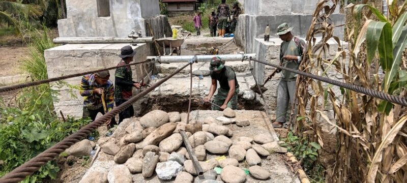Personel Satgas Jembatan Gantung Perintis bersama tukang dan masyarakat bergotong royong melakukan penggalian dan penyiapan pondasi pembangunan Jembatan Gantung Perintis di Desa Lawe Pinis, Kecamatan Darul Hasanah, Aceh Tenggara, Minggu (30/8/2026). Foto: Dok. Istimewa 