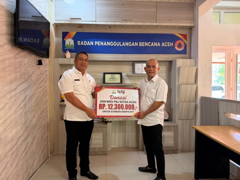 Plt. Kepala Biro PBJ Setda Aceh Ir. Afria menyerahkan donasi sebesar Rp12,3 juta kepada Plt. Sekretaris BPBA Abd. Aziz untuk membantu korban gempa bumi di Nusa Tenggara Timur (NTT), di Kantor BPBA, Banda Aceh, Rabu (26/8/2026). Foto: Dok. Istimewa 