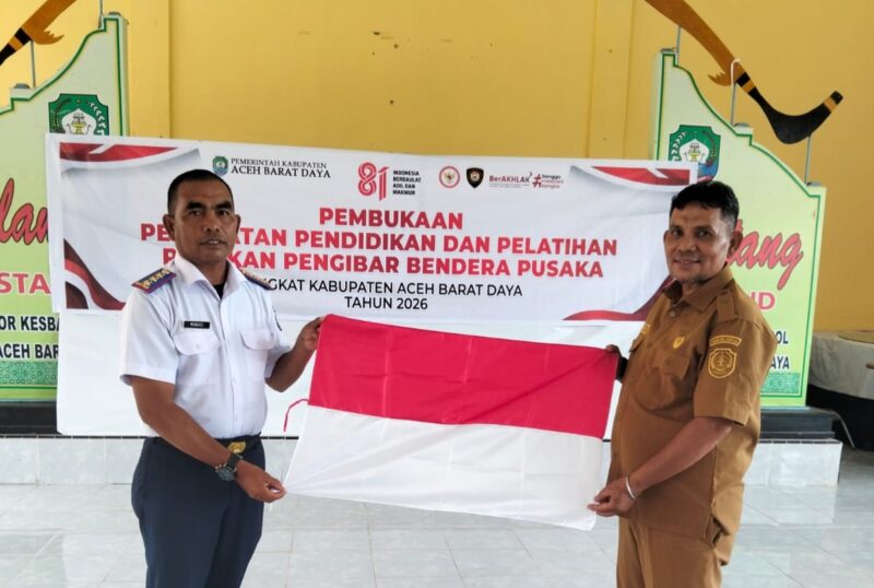 Kepala Kesbangpol saat menerima bendera merah putih dari Sekretaris Dinas Perhubungan Abdya. Foto. Dok. Teukunizar/noa.co.id