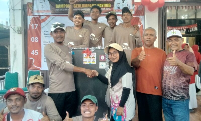 Keuchik Gampong Geulumpang Payong, Khairuddin SH diabadikan bersama panitia dan salah seorang pemenang hadiah utama jalan santai HUT RI ke-81 Gampong setempat. Foto. Dok. Teukunizar/noa.co.id