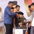 Bupati Safaruddin menyerahkan santunan kepada anak yatim di halaman masjid Agung Baitul Ghafur Abdya. Foto. Dok. Teukunizar/noa.co.id