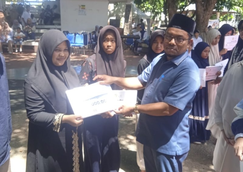 Ketua Baitul Mal Kota Banda Aceh Yusuf Al Qardhawy menyerahkan santunan kepada anak yatim pada puncak peringatan Hari Anak Nasional (HAN) 2026 di Taman Putroe Phang, Minggu (2/8/2026). Foto: Dok. Diskominfo Kota Banda Aceh