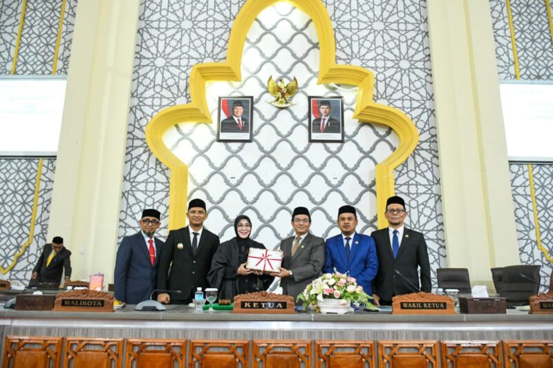 Wali Kota Banda Aceh Illiza Sa’aduddin Djamal menyerahkan dokumen RKUA-PPAS Tahun Anggaran 2027 kepada Ketua DPRK Banda Aceh Irwansyah dalam rapat paripurna di Gedung DPRK Banda Aceh, Senin (3/8/2026). Foto: Dok. Prokopim Kota Banda Aceh