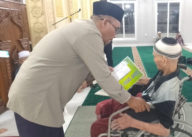 Ketua Baitul Mal Kota Banda Aceh Yusuf Al Qardhawy menyerahkan santunan zakat kepada Muhammad Amin, mualaf yang baru bersyahadat di Masjid Ar-Rahman, Gampong Panteriek, Kecamatan Lueng Bata, Banda Aceh, Rabu (20/8/2026) malam. Foto: Dok. Diskominfo Kota Banda Aceh