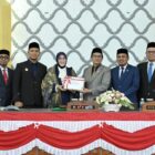 Wali Kota Banda Aceh Illiza Sa’aduddin Djamal menyerahkan dokumen RKUA-PPAS Perubahan APBK Tahun Anggaran 2026 kepada Ketua DPRK Banda Aceh Irwansyah ST didampingi Wakil Ketua Daniel Abdul Wahab dan Musriadi Aswad dalam sidang paripurna di Gedung DPRK Banda Aceh, Senin (24/8/2026). Foto: Dok. DPRK Banda Aceh