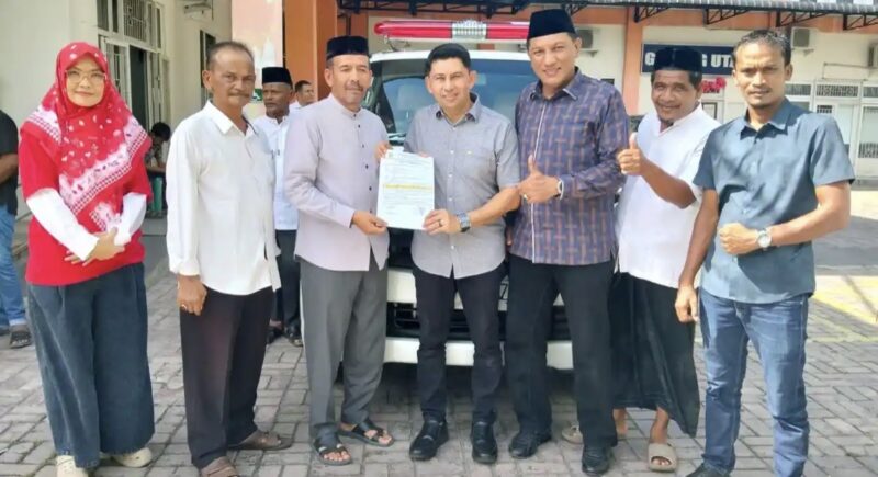 Kepala Dinas Kesehatan Kota Banda Aceh Wahyudi didampingi Ketua Fraksi PAN DPRK Banda Aceh Sofyan Helmi menyerahkan ambulans kepada Keuchik Gampong Ateuk Jawo Yusri Abidin, Jumat (14/8/2026). Foto: Dok. Istimewa 