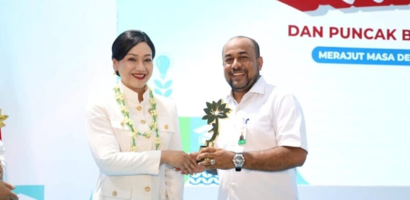 Direktur Utama Bank Aceh Syariah Fadhil Ilyas menerima KEJAR Award OJK Pusat 2026 dari Ketua Dewan Komisioner OJK Friderica Widyasari Dewi dalam rangkaian Puncak Hari Indonesia Menabung dan Bulan Literasi Keuangan 2026 di Sekolah Rakyat 13 Bekasi, Jumat (28/8/2026). Foto: Dok. Istimewa