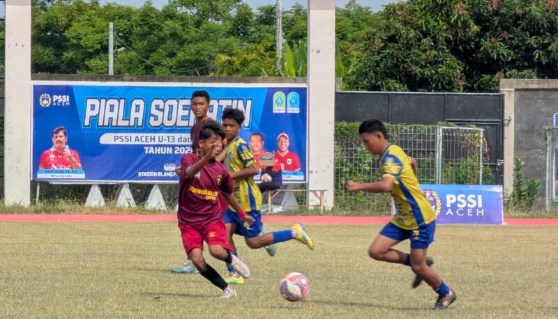 Pemain Elang Biru Langsa memakai kustum warna kuning menggiring bola dan dihadang pemain SSB Rawa Aceh Singkil memakainkustum warna merah pada pertandingan Piala Soeratin U-15 Regional Aceh di Stadion Blang Paseh Kota Sigli Kabupaten Pidie, Senin (24/8/2026) (Foto.Amir Sagita).