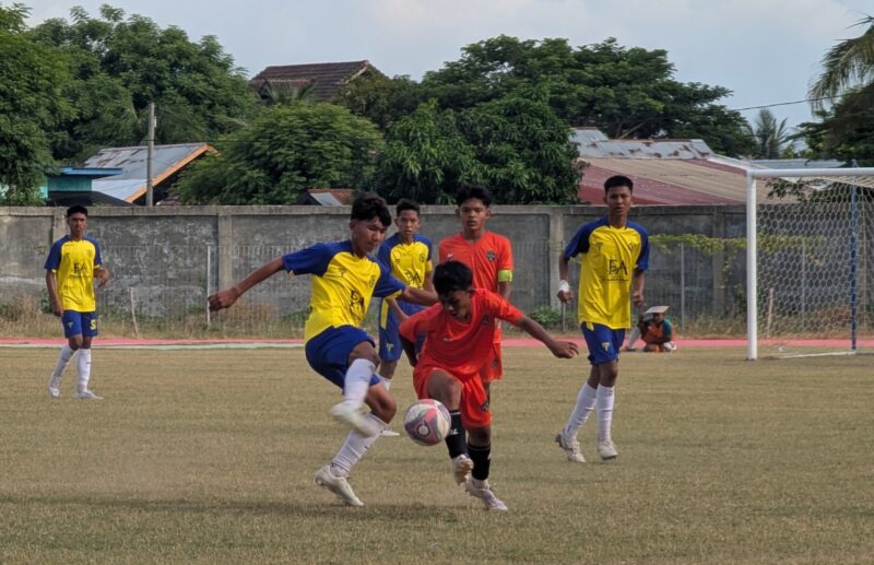 Pemaian MAN I Pidie memakai kustum warna merah saat menggiring bola dan dihadang pemain Talenta FA Banda Aceh memakai kustum warna kuning pada laga Piala Soeratin U-15 Regional Aceh di Stadion Blang Paseh Kota Sigli, Selasa (25/8/2026) (Foto.Amir Sagita.NOA.co.id).