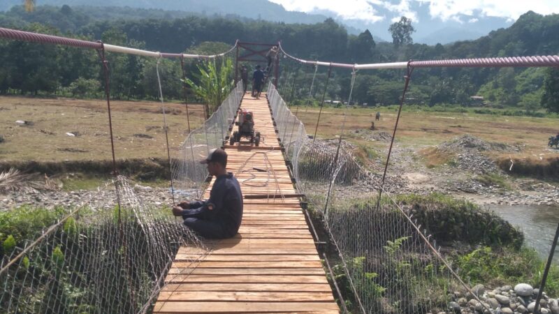 Babinsa Posramil Deleng Pokhkisen bersama masyarakat memasang besi pagar pengaman pada Jembatan Beton di Desa Bunga Melur, Kecamatan Deleng Pokhkisen, Aceh Tenggara, Minggu (9/8/2026). Foto: Dok. Istimewa 