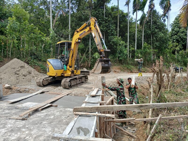 Personel Satgas TMMD Reguler ke-129 Kodim 0102/Pidie memasang cerucuk kayu menggunakan mini excavator sebagai penahan bantaran jalan pada pembangunan Jembatan Box Culvert di Desa Lhok Panah, Kecamatan Sakti, Jumat (7/8/2026). Foto: Dok. Istimewa 