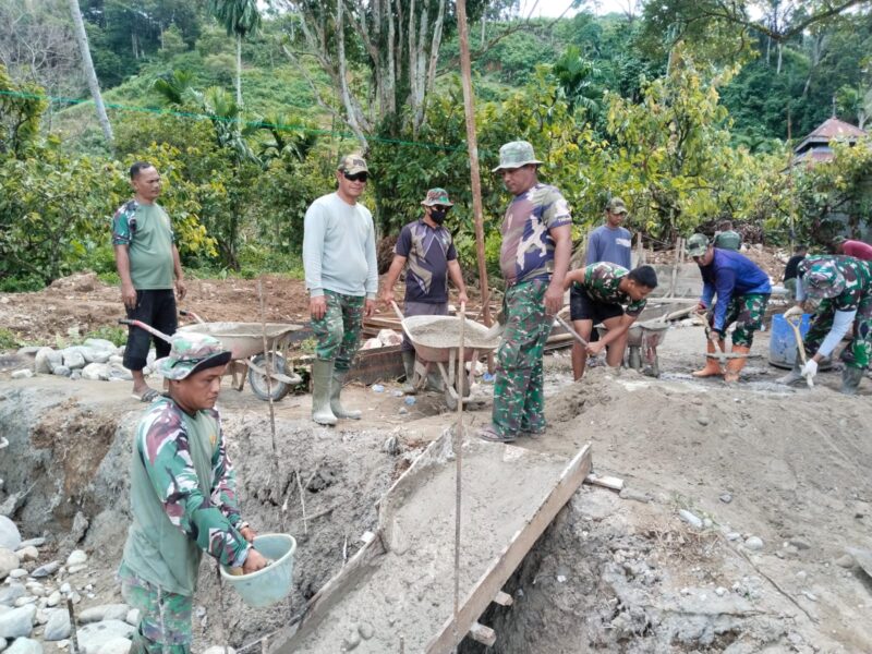 Babinsa Kodim 0108/Aceh Tenggara bersama masyarakat dan teknisi bergotong royong memasang tiang pylon Jembatan Gantung Perintis di Desa Lawe Ger-Ger, Kecamatan Ketambe, Kamis (6/8/2026). Foto: Dok. Istimewa 