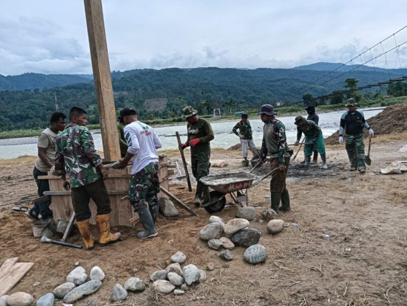 Babinsa Kodim 0108/Aceh Tenggara bersama Satgas pembangunan Jembatan Gantung Perintis dan masyarakat bergotong royong melakukan pengecatan tiang penahan jembatan di Desa Gulo, Kecamatan Darul Hasanah, Kamis (6/8/2026). Foto: Dok. Istimewa 