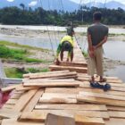 Personel Satgas Jembatan Gantung Perintis Kodim 0108/Aceh Tenggara bersama teknisi memasang papan lantai jembatan di Desa Kuta Ujung, Kecamatan Darul Hasanah, Aceh Tenggara, Jumat (7/8/2026). Foto: Dok. Istimewa