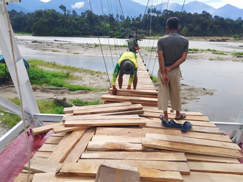 Personel Satgas Jembatan Gantung Perintis Kodim 0108/Aceh Tenggara bersama teknisi memasang papan lantai jembatan di Desa Kuta Ujung, Kecamatan Darul Hasanah, Aceh Tenggara, Jumat (7/8/2026). Foto: Dok. Istimewa 