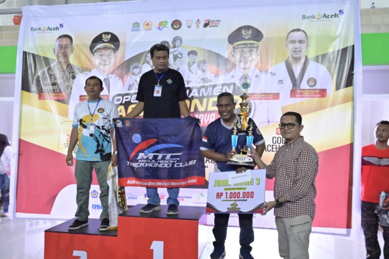 Kepala Dinas Parekrafpora Aceh Jaya, Muhammad Milsa, menyerahkan hadiah kepada peraih juara pada Taekwondo Aceh Jaya Bupati Open Championship 2026 di GOR PBVSI Aceh Jaya, Minggu (27/9/2026). Foto: Dok. Istimewa