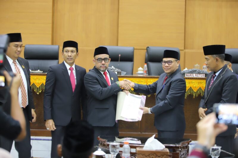 Ketua DPRK Pidie menyerahkan nota kesepakatan KUPA PPAS kepada Wakil Bupati Pidie, Alzaizi usai menutup rapat di Gedung DPRK setempat Selasa malam (15/9/2026) (Foto.IST)