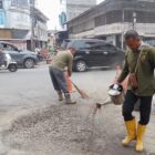 Petugas dari PUPR Abdya melakukan tambal sulam pada jalan yang berlubang di jalan pusat Kota Blangpidie. Foto. Dok. Teukunizar/nona.co.id
