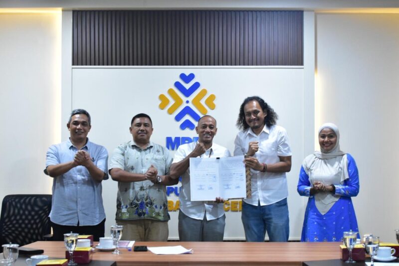 Kepala DPMPTSP Banda Aceh Mohd. Ichsan bersama peserta dan pemangku kepentingan menunjukkan dokumen hasil forum konsultasi publik penyusunan Standar Pelayanan Perizinan Berusaha dan Non Berusaha di Banda Aceh, Jumat (11/9/2026). Foto: Dok. Diskominfo Kota Banda Aceh