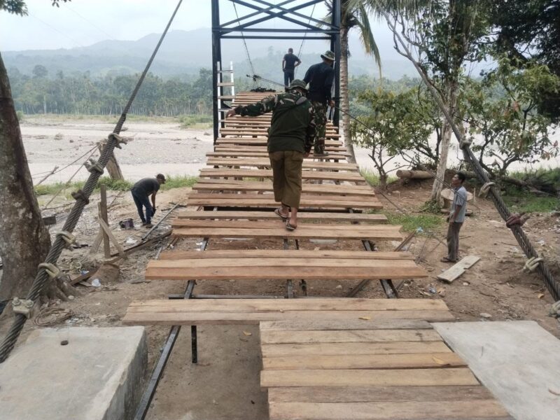 Babinsa, teknisi, dan masyarakat bergotong royong memasang papan lantai Jembatan Gantung Perintis di Desa Lawe Ger Ger, Kecamatan Ketambe, Kabupaten Aceh Tenggara, Kamis (17/9/2026). Foto: Dok. Istimewa 