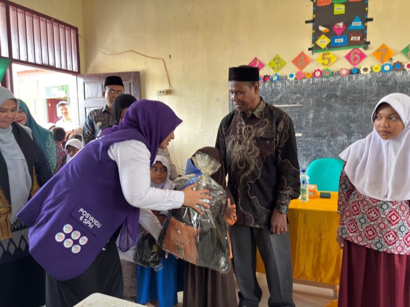 Ketua Posyandu Kabupaten Aceh Barat, Afrinda Novalia, menyerahkan bantuan perlengkapan sekolah kepada siswa terdampak bencana hidrometeorologi di SDN Alue Lhok, Kecamatan Pante Ceureumen, Kamis (29/10/2026). Foto: Dok. Istimewa 