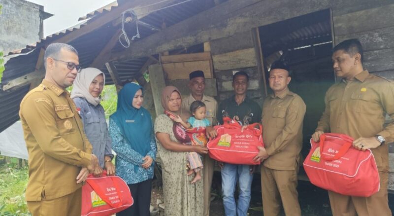 Bupati Aceh Jaya, Safwandi, bersama Ketua TP-PKK Aceh Jaya, Ny. Desi Maulidur, menyerahkan bantuan masa panik kepada Zamzami, warga Desa Tuwie Kareung, Kecamatan Pasie Raya, yang rumahnya tertimpa pohon tumbang, Senin (12/10/2026). Foto: Dok. Istimewa