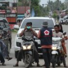 Relawan PMI Pidie Jaya membagikan masker kepada warga pelintas, Simpang Jalan Layang. Meureudu (19/10/2026). Foto:Dok/Nasruddin