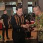 Wakil Gubernur Aceh, H. Fadhlullah, didampingi Ketua Staf Shli TP-PPK Aceh Ny. Mukarramah Fadhlullah, saat menyerahkan cinderamata kepada Mayjen TNI Joko Hadi Susilo, S.I.P pada acara Malam Lepas Sambut dan Serah Terima Jabatan (Sertijab) Panglima Kodam Iskandar Muda (Pangdam IM) di Makodam IM, Banda Aceh, Senin (19/10/2026). Foto: Dok. Biro Adpim Setda Aceh 