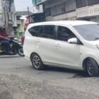 Kenderan melewati jalan berlubang di depan tokoh masyarakat Diamond Kota Blangpidie. Foto. Dok. Teukunizar/noa.co.id